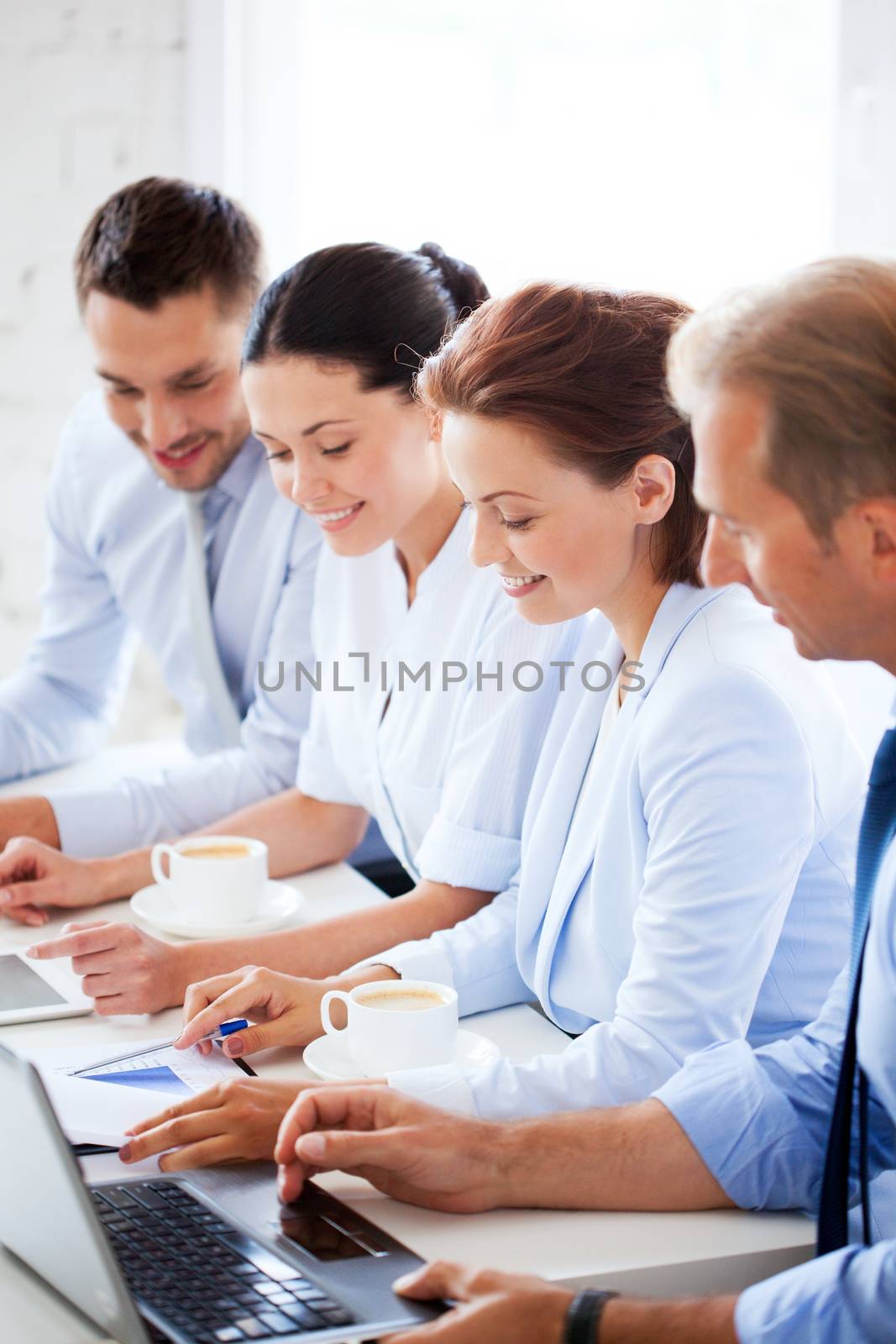 group of people working with laptops in office by dolgachov