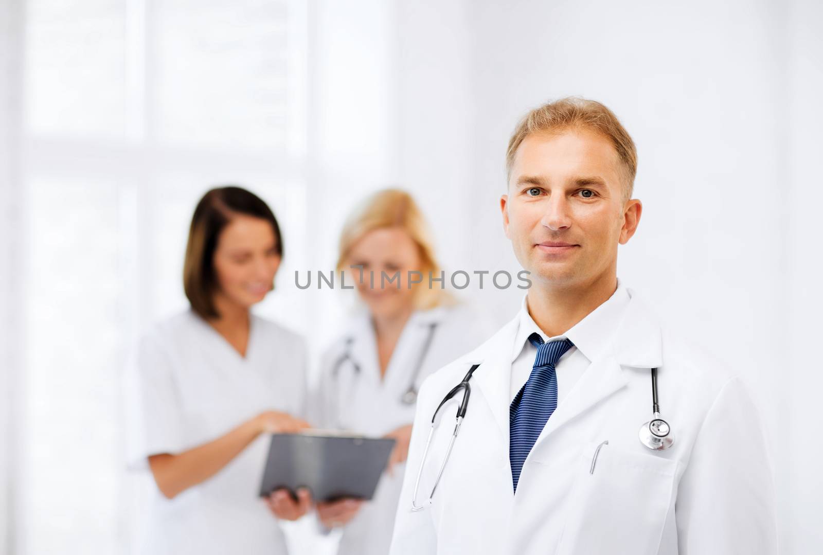 healthcare and medical concept - young male doctor with colleagues in hospital