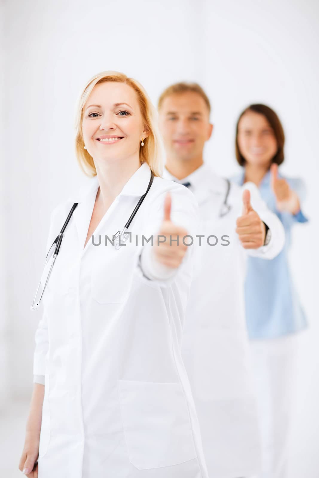 team of doctors showing thumbs up by dolgachov