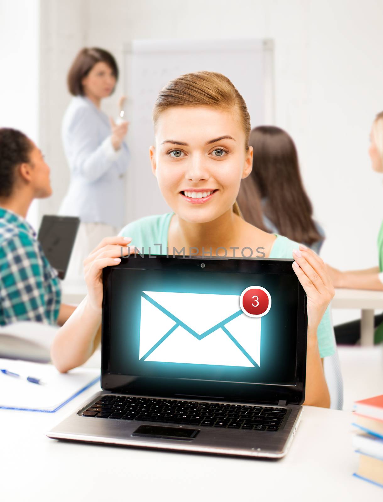 girl holding laptop with email sign at school by dolgachov