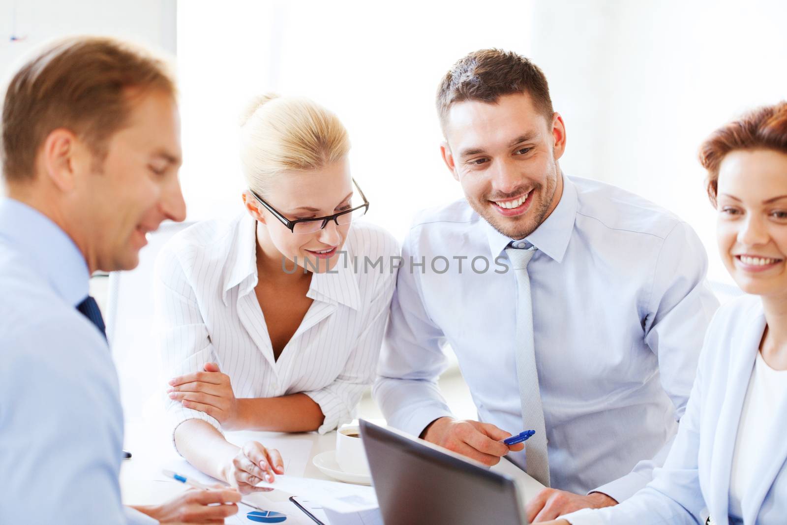 smiling businesswoman with team on meeting in office