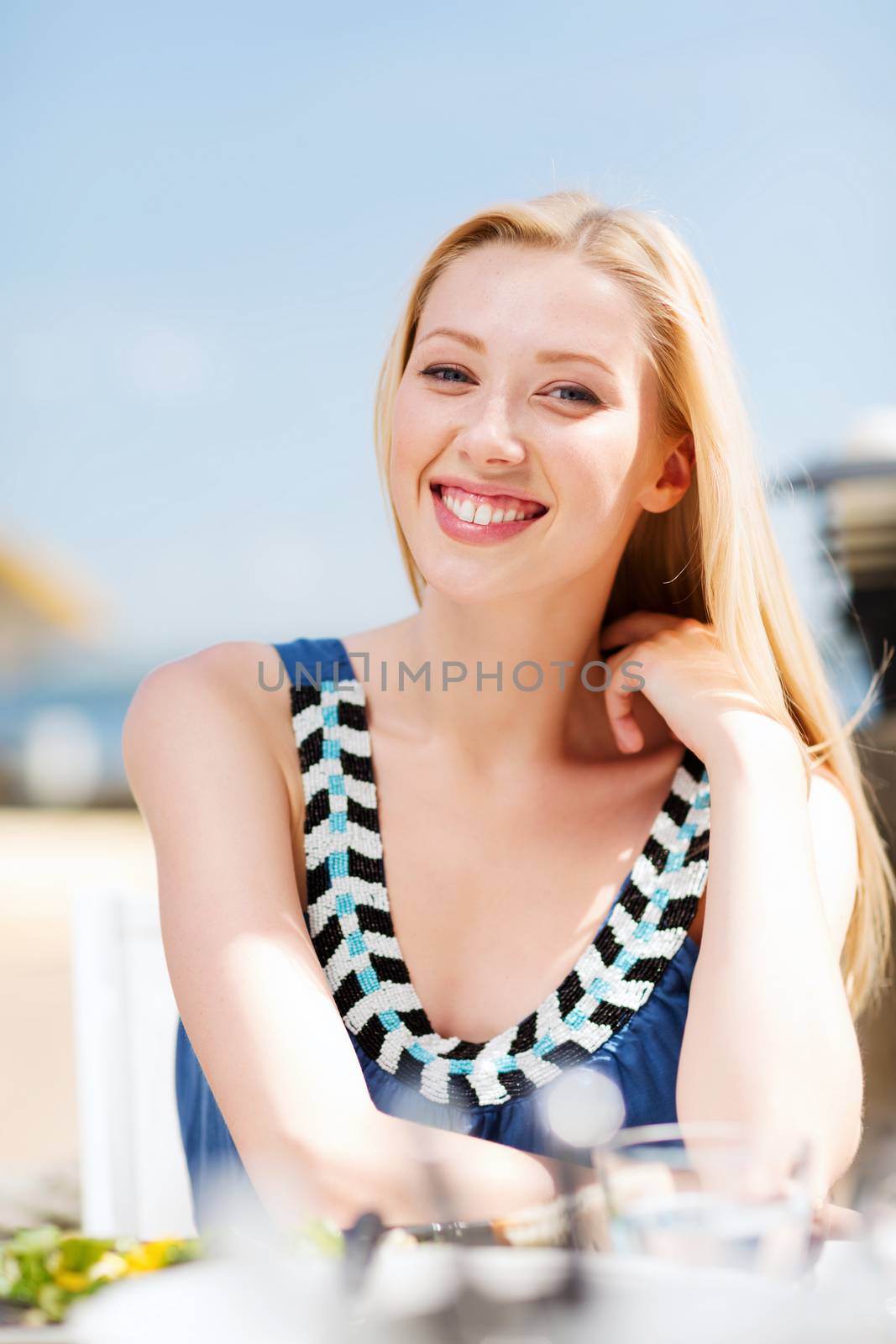 summer holidays and vacation - girl in cafe on the beach