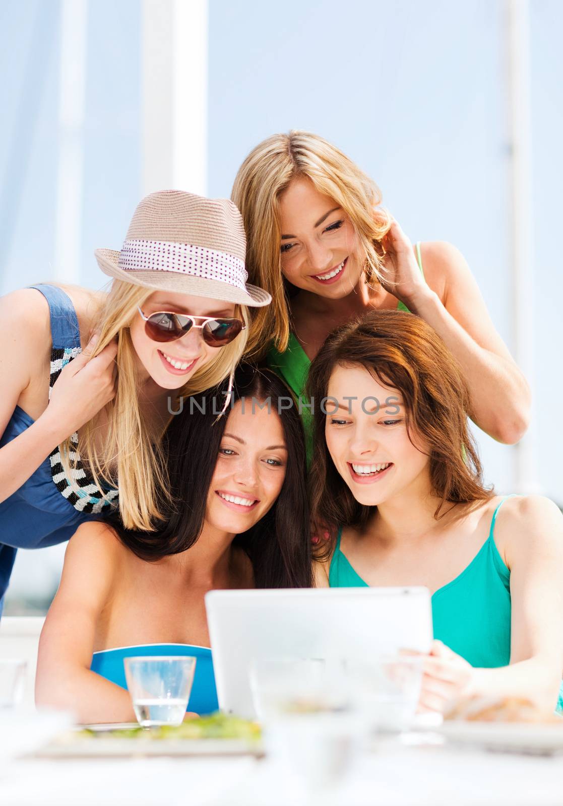 summer holidays, vacation, internet and technology - girls looking at tablet pc in cafe