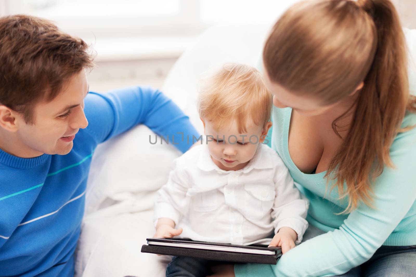 happy parents and adorable baby with tablet pc