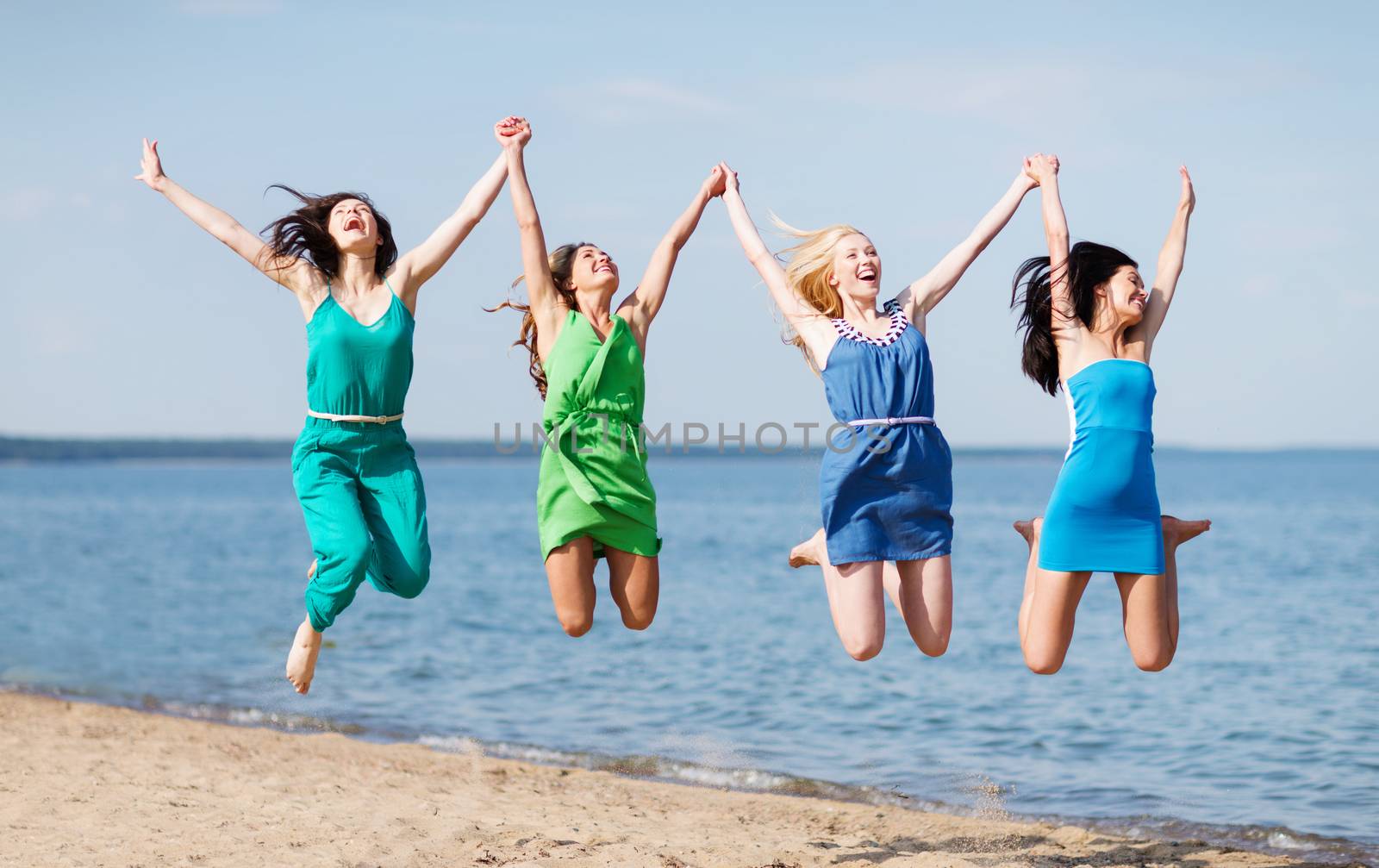 girls jumping on the beach by dolgachov