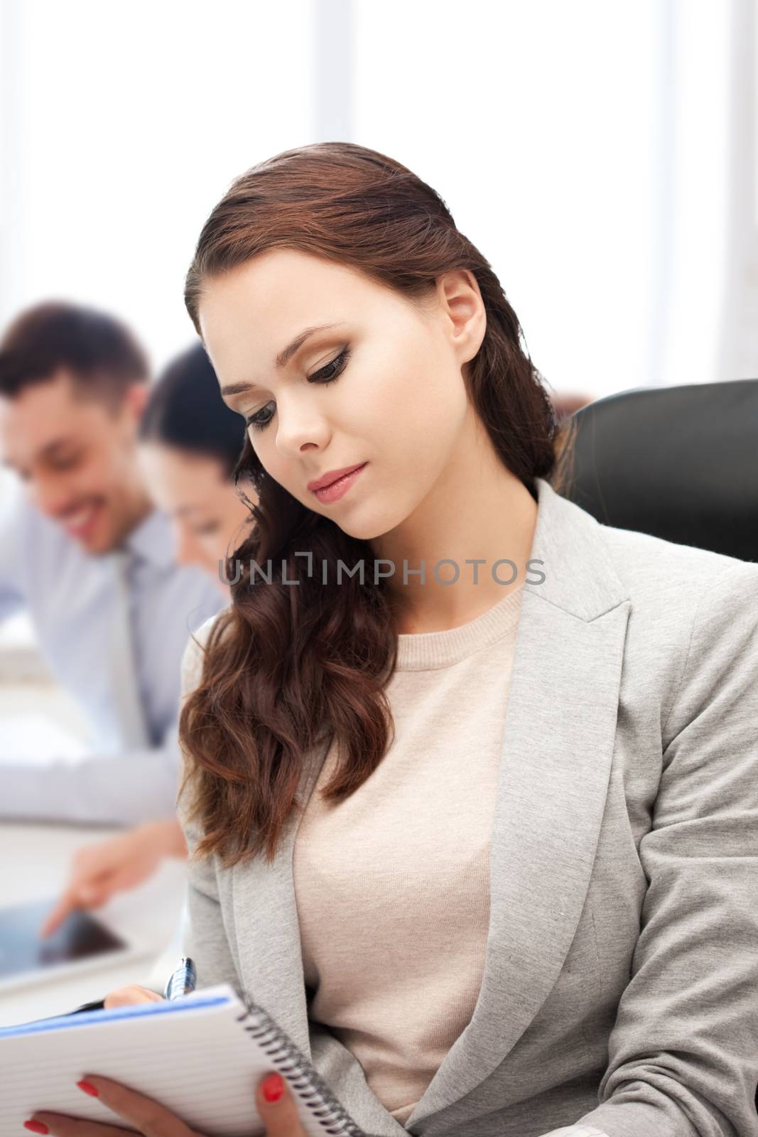 attractive businesswoman taking notes in office by dolgachov