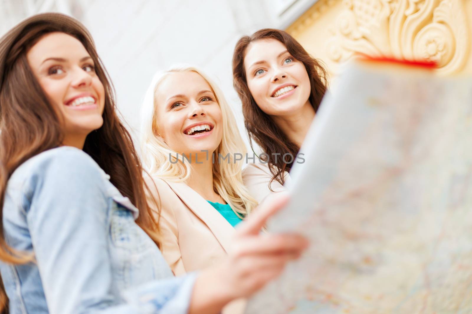 beautiful girls looking into tourist map in city by dolgachov
