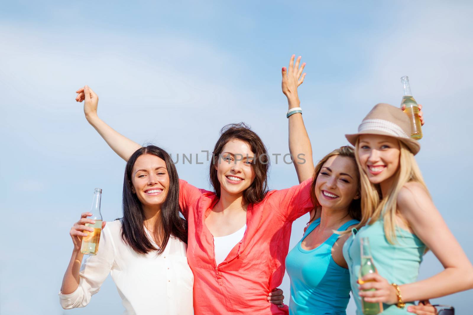 summer holidays and vacation - girls with drinks on the beach