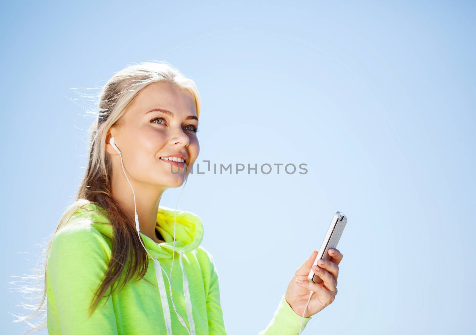woman listening to music outdoors by dolgachov