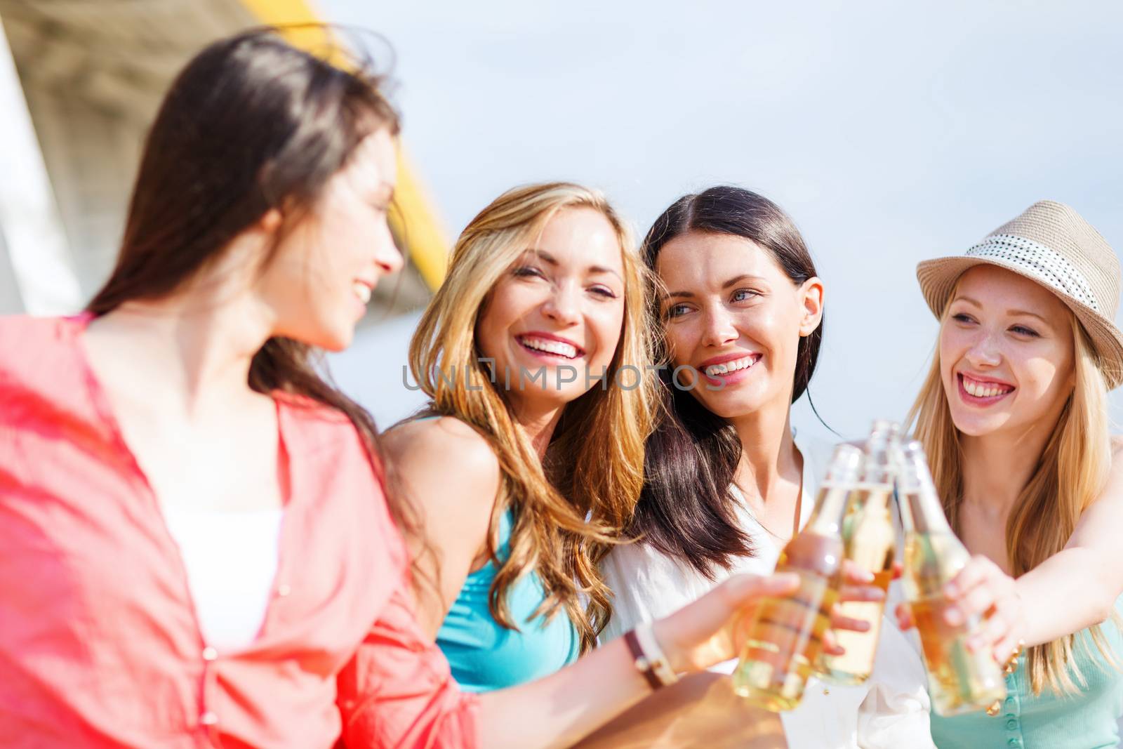 summer holidays and vacation - girls with drinks on the beach