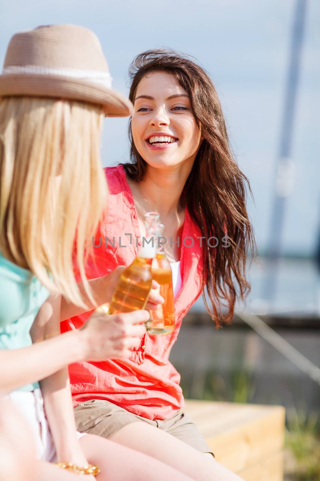 summer holidays and vacation - girls with drinks on the beach