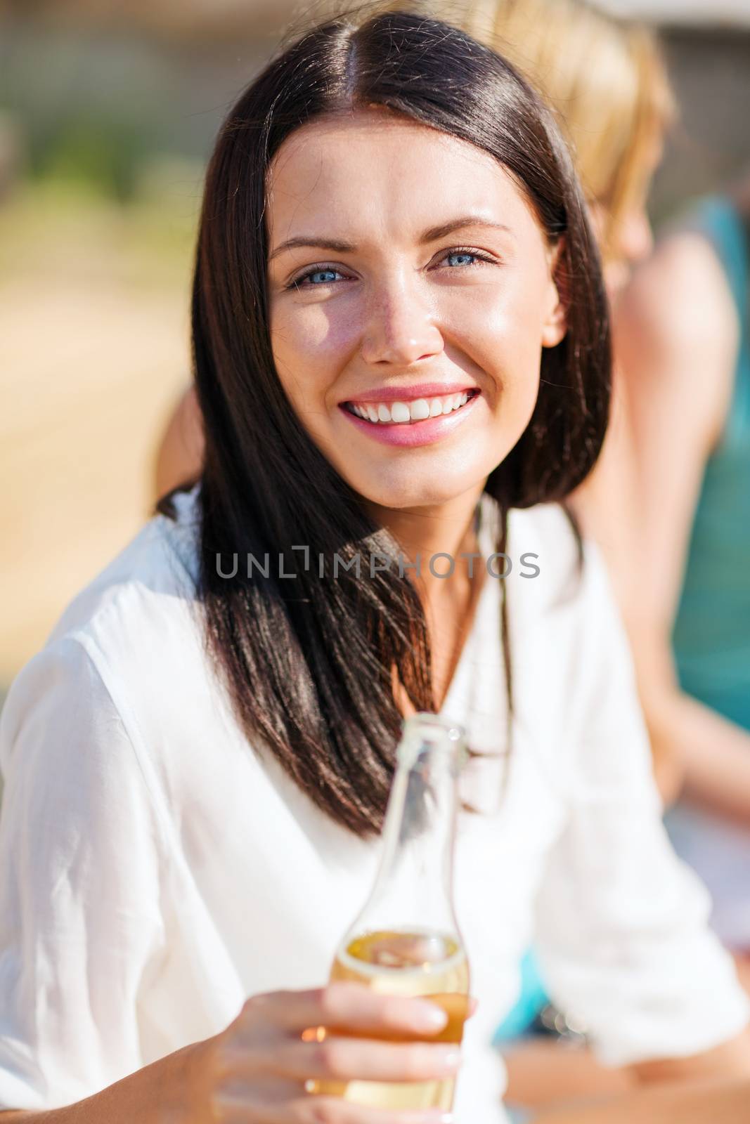 summer holidays and vacation - girl with drink and friends on the beach