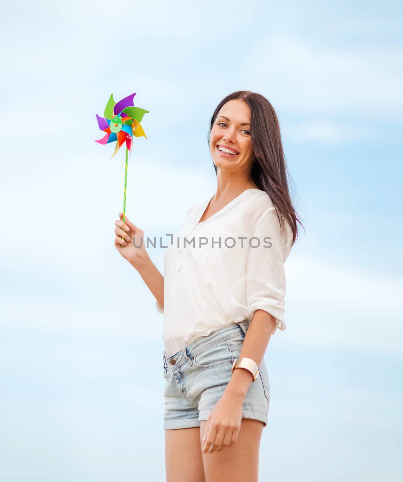 summer holidays, vacation and ecology - girl with windmill toy on the beach