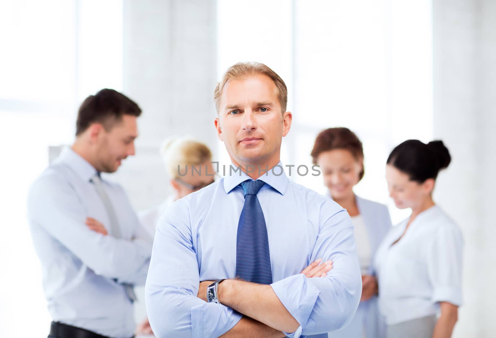 handsome businessman with team in office by dolgachov