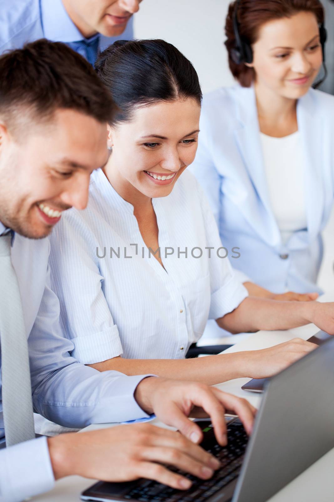 picture of group of people working with laptops in office