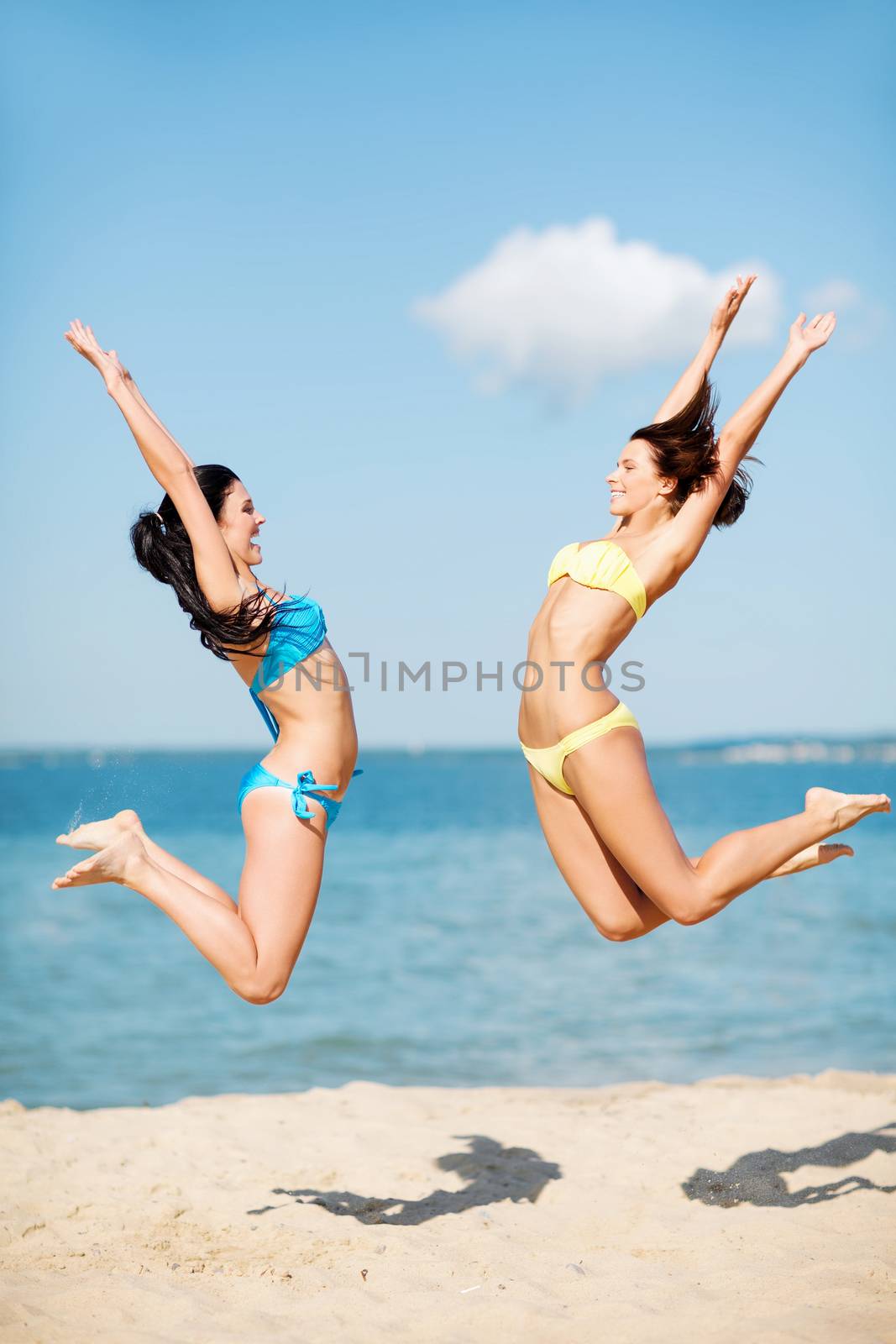girls jumping on the beach by dolgachov