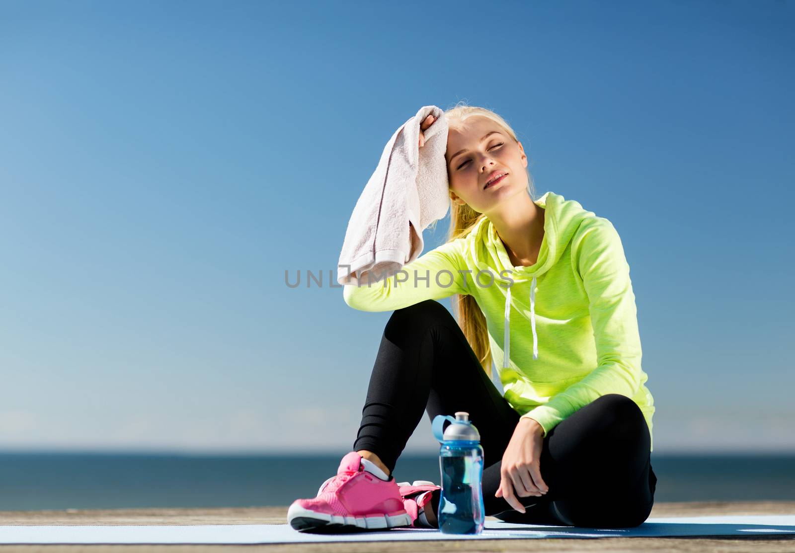 sport and lifestyle concept - woman resting after doing sports outdoors