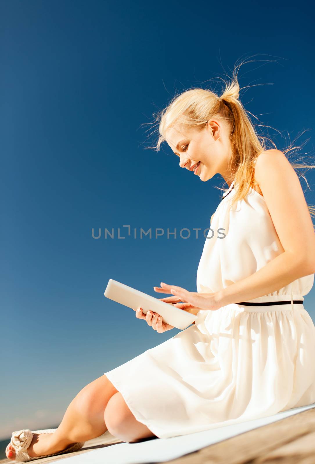 beautiful smiling woman with tablet pc outdoors by dolgachov