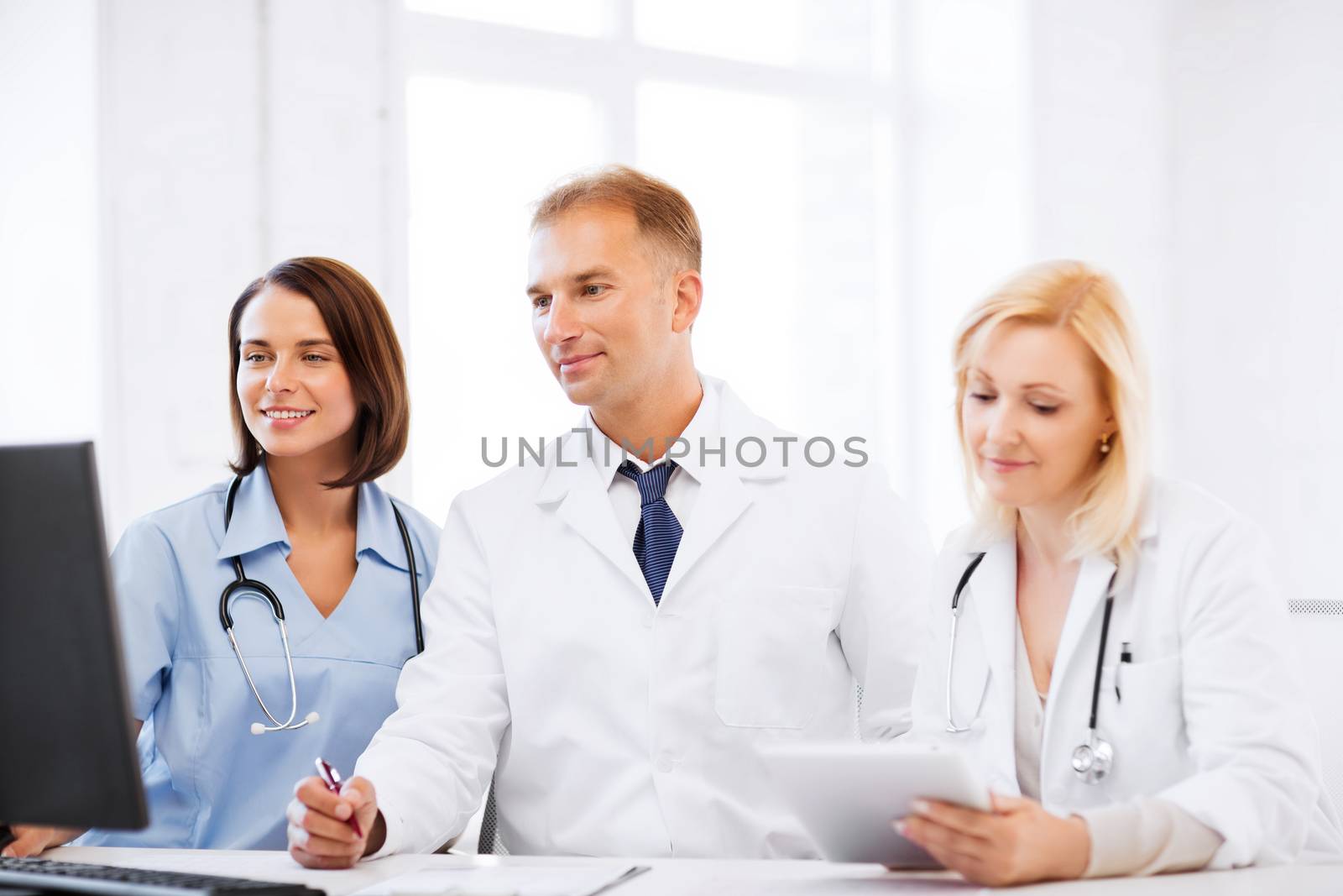 healthcare, medical and technology - group of doctors looking at computer on meeting