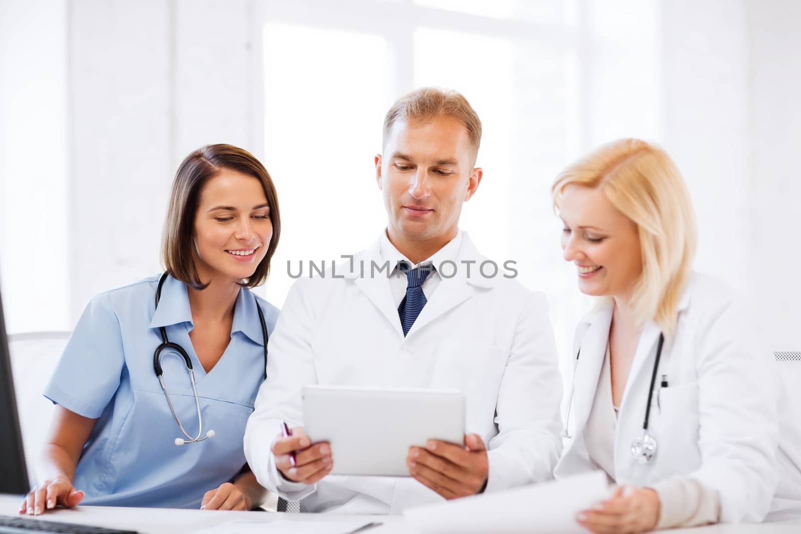 doctors looking at tablet pc by dolgachov