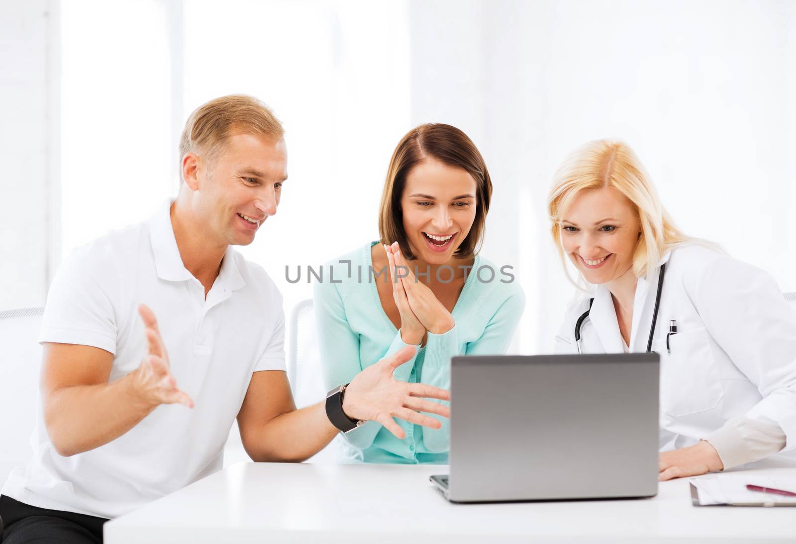 doctor with patients looking at laptop by dolgachov