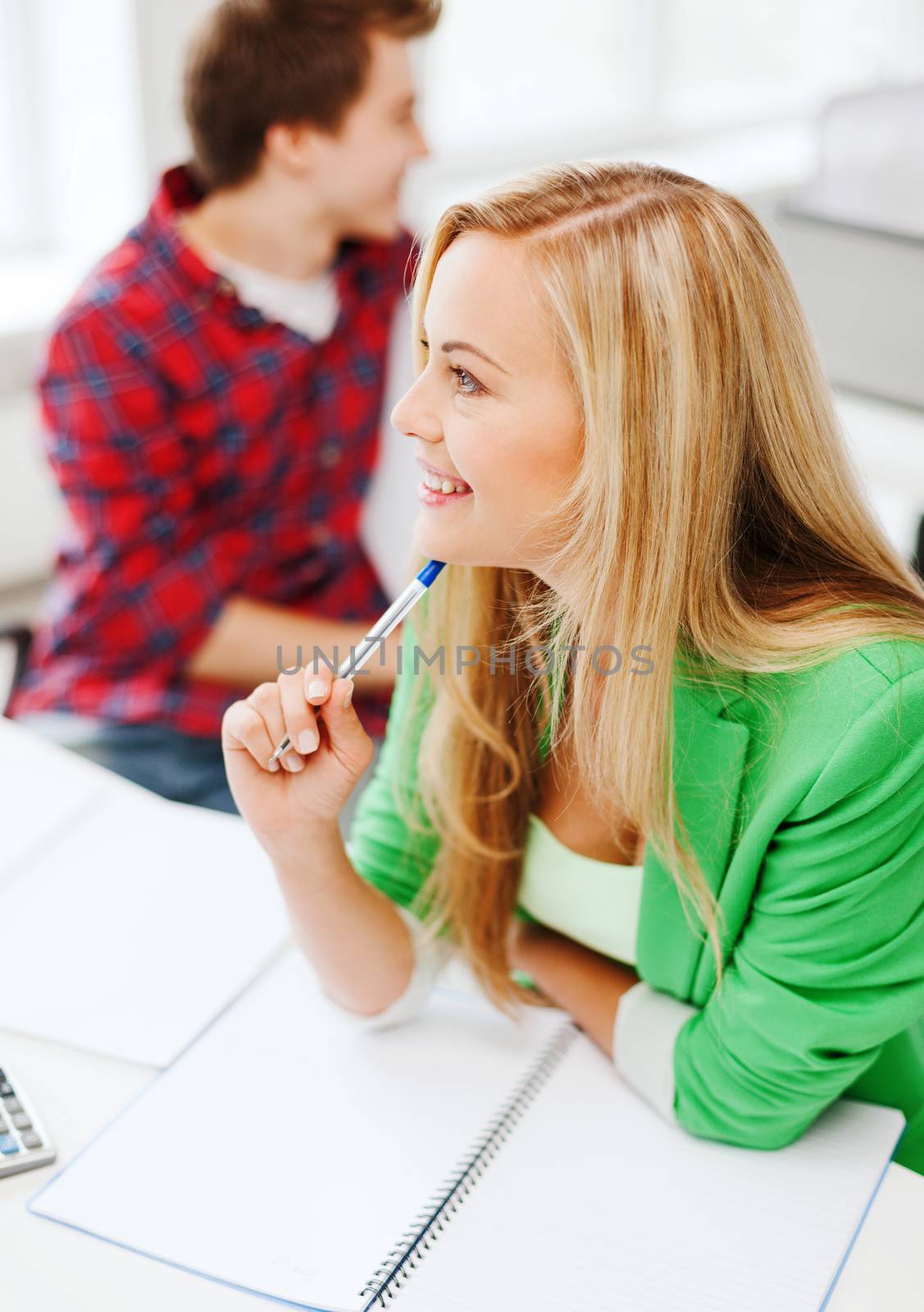 education concept - smiling student girl studying in college