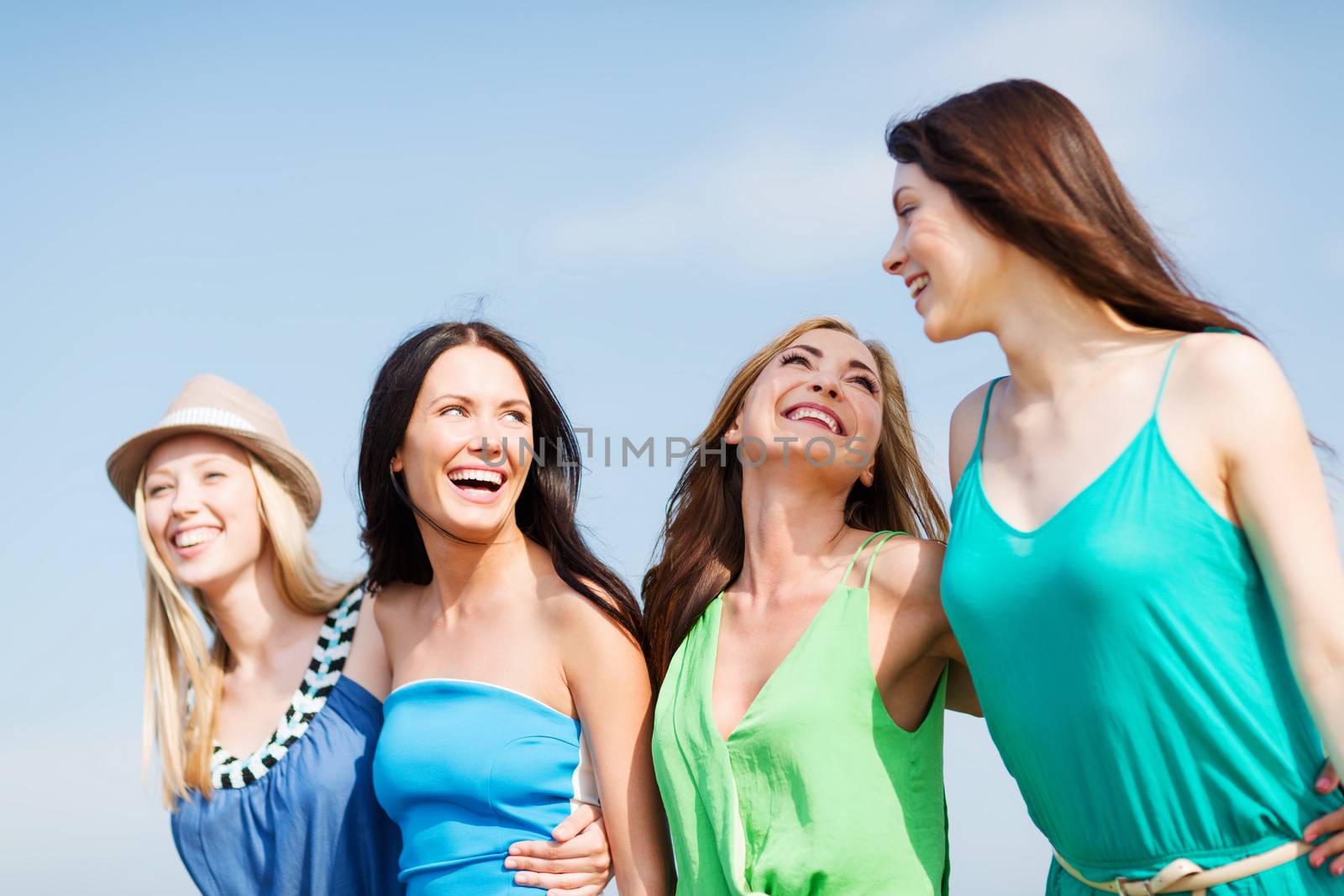 summer holidays and vacation - girls walking on the beach