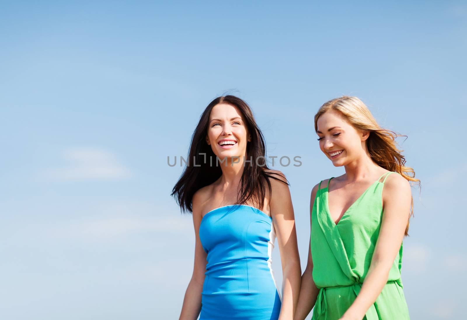 summer holidays and vacation - girls walking on the beach