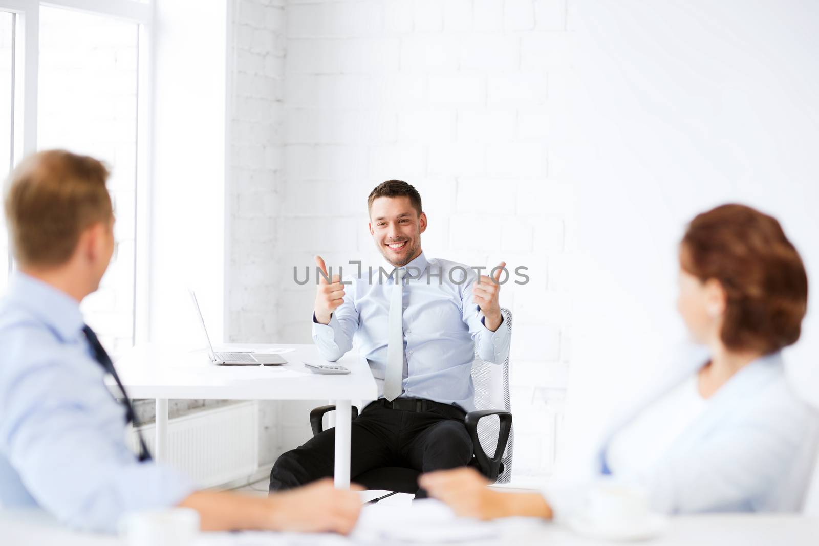 business concept - businessman showing thumbs up in office