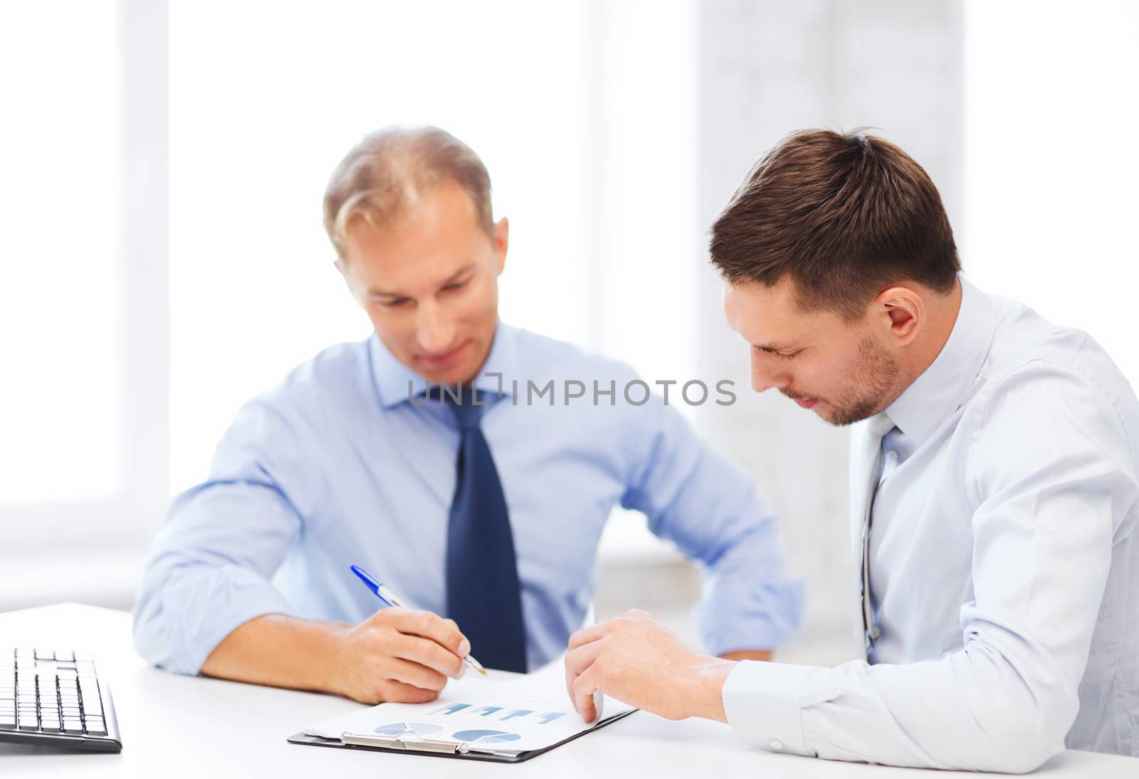businesss concept - two businessmen discussing graphs on meeting