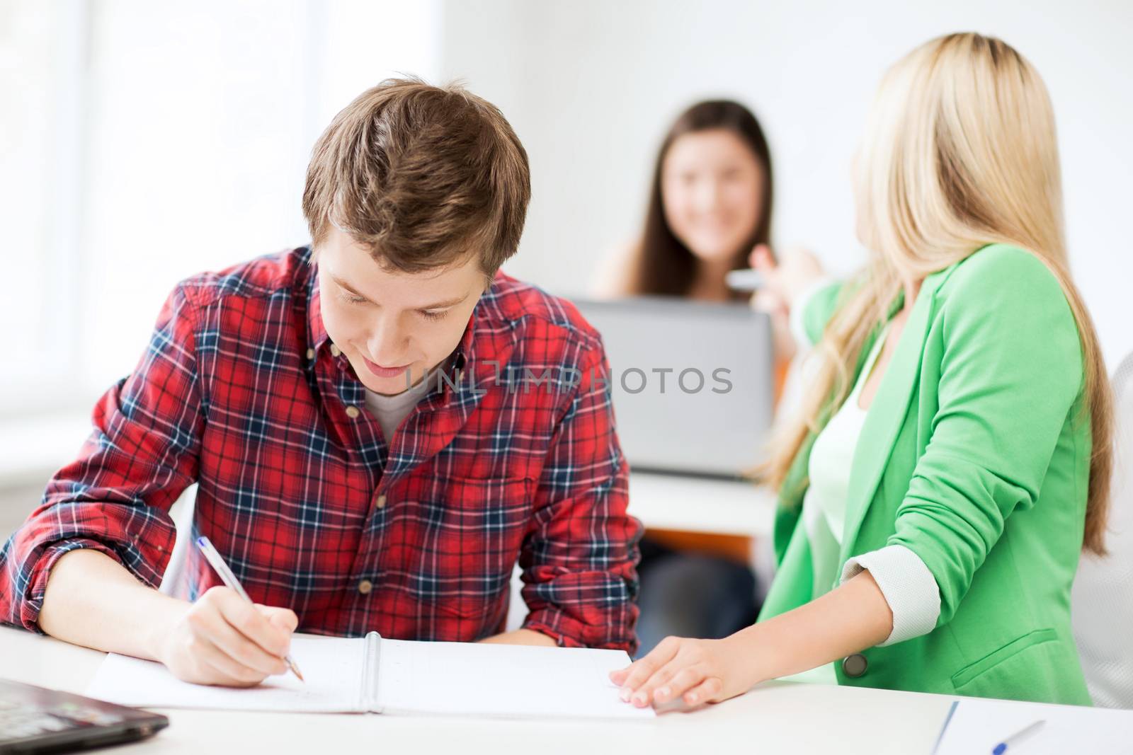 students writing something at school by dolgachov