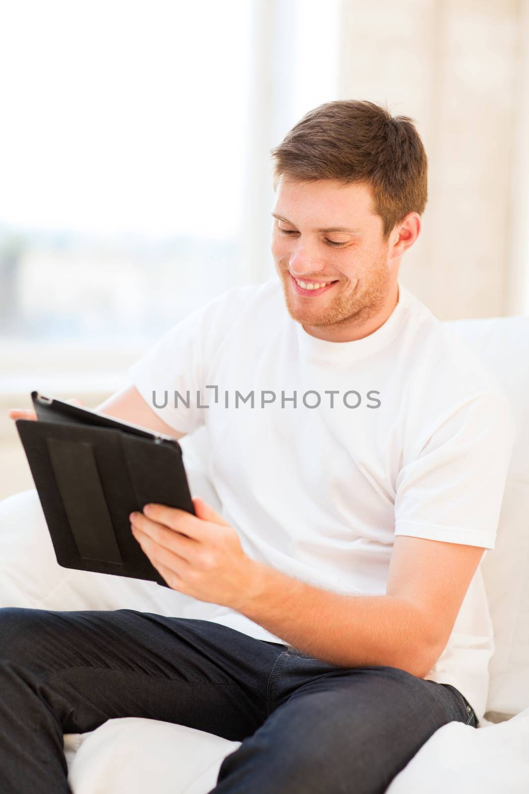 man working with tablet pc at home by dolgachov