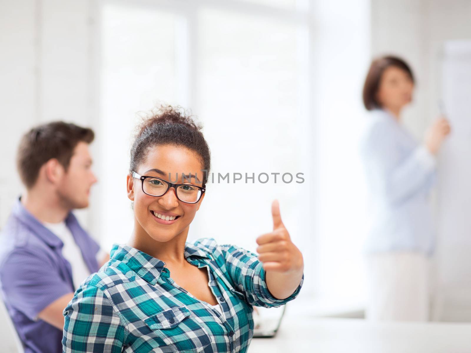 education concept - african student girl showing thumbs up at school