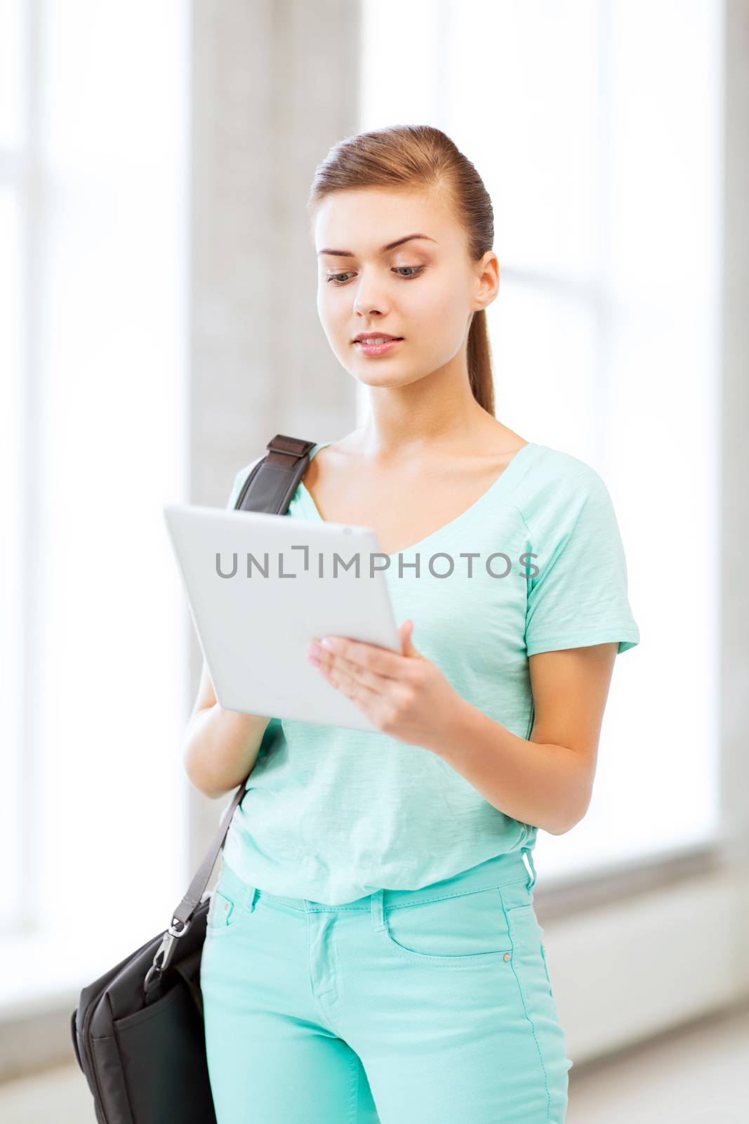 smiling student with tablet pc in college by dolgachov