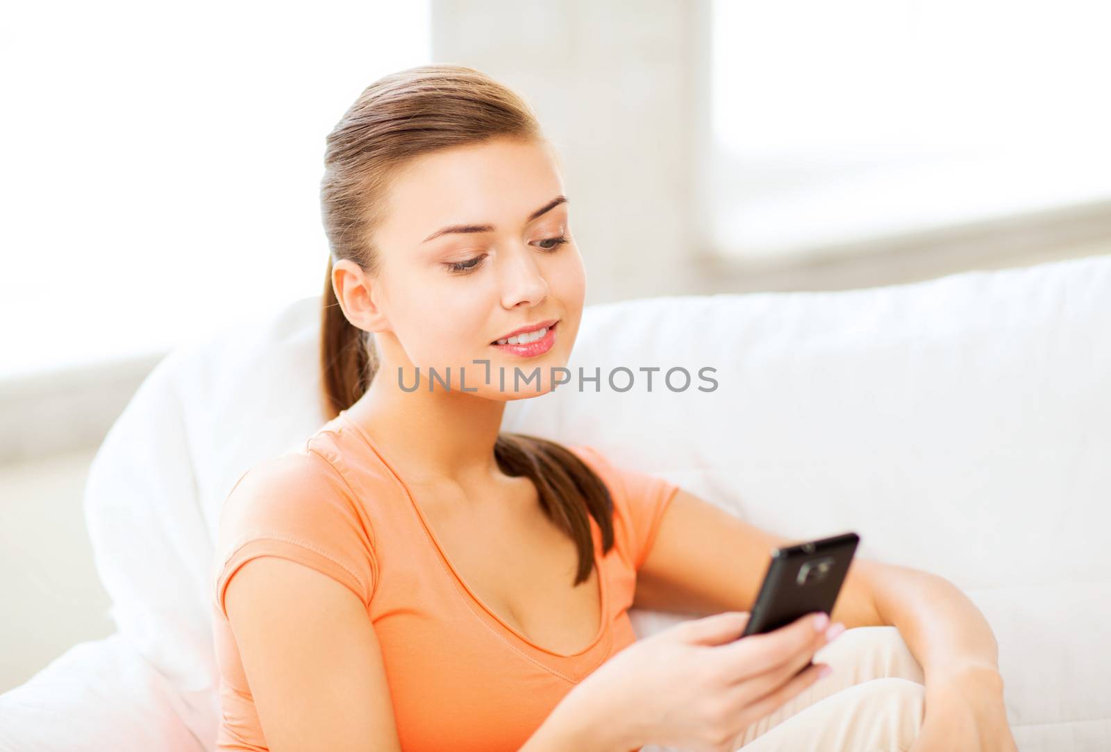 home, communication and internet - woman sitting on the couch with smartphone at home