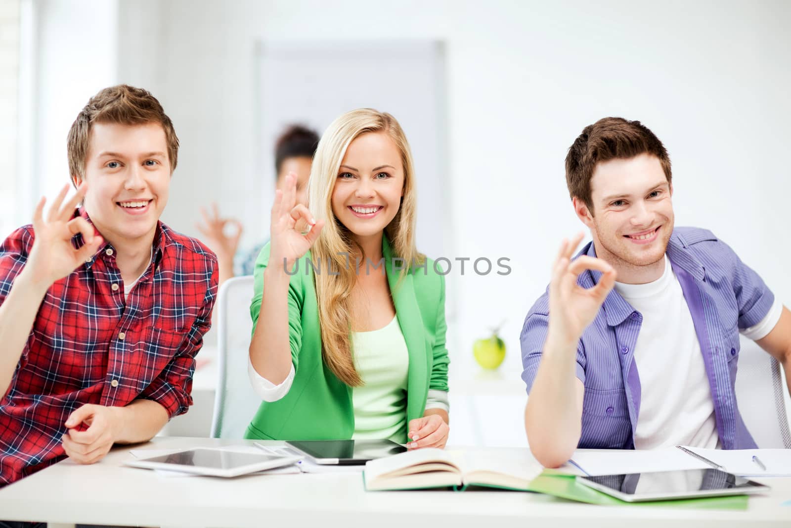 education and technology- smiling students with tablet pcs showing ok sign at school