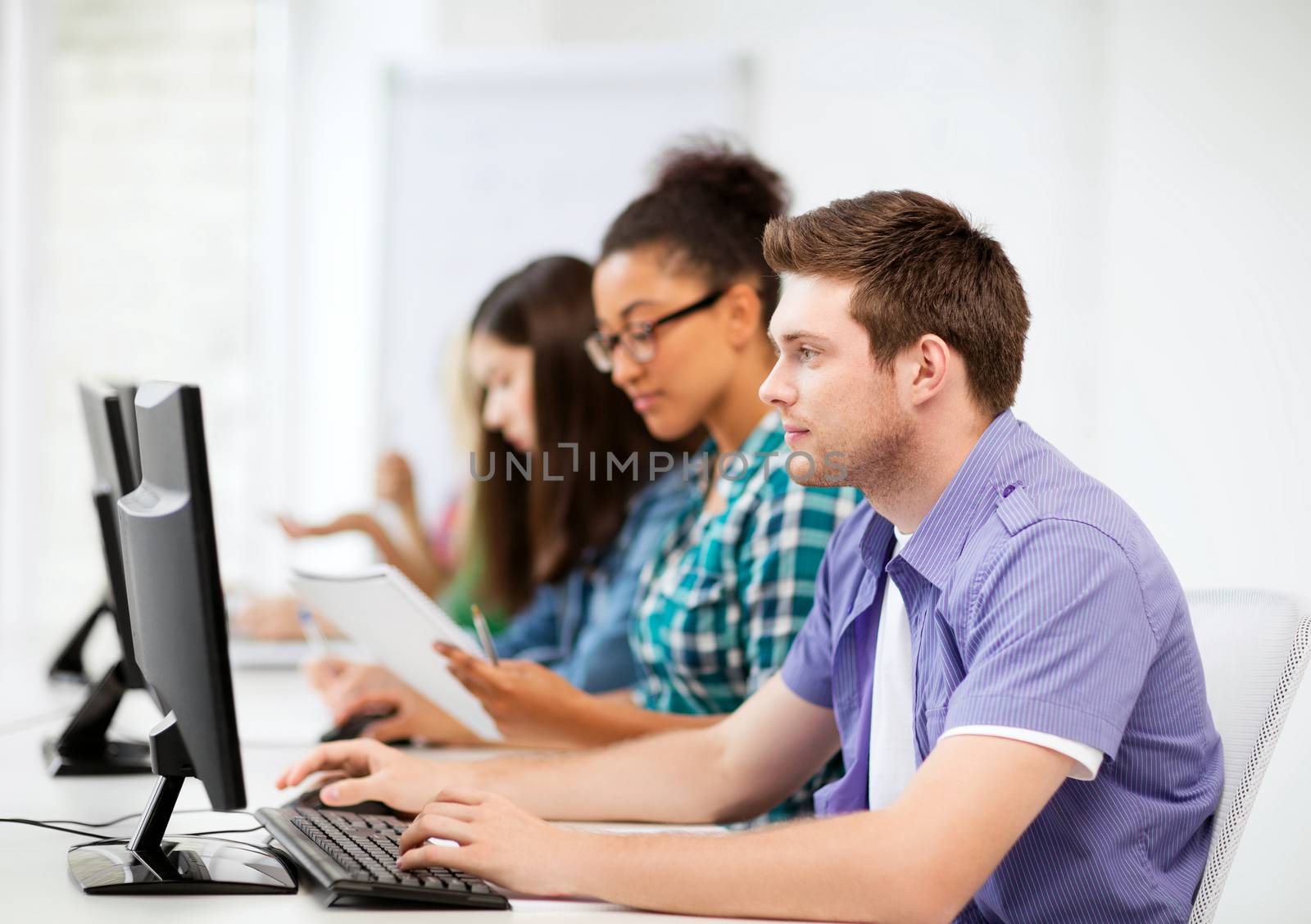 students with computers studying at school by dolgachov