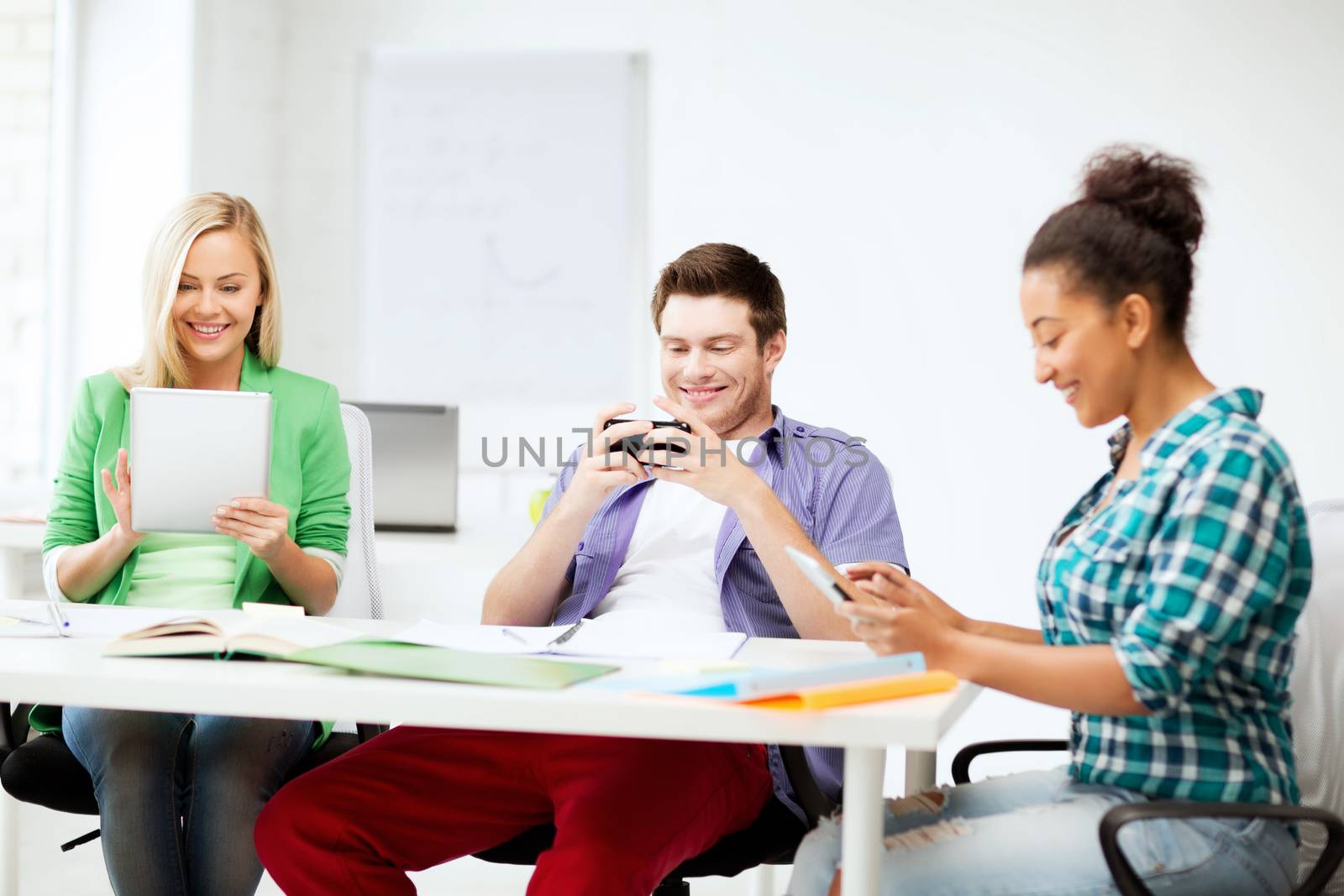 students looking into devices at school by dolgachov