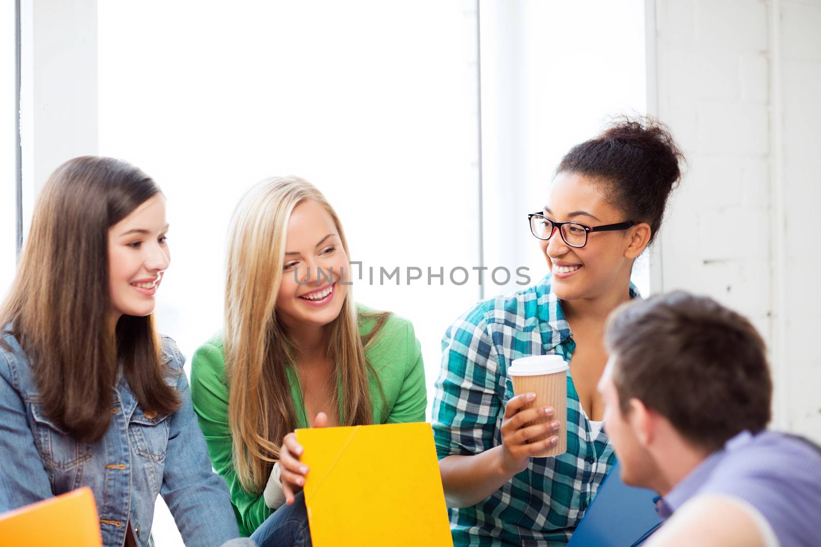 students communicating and laughing at school by dolgachov