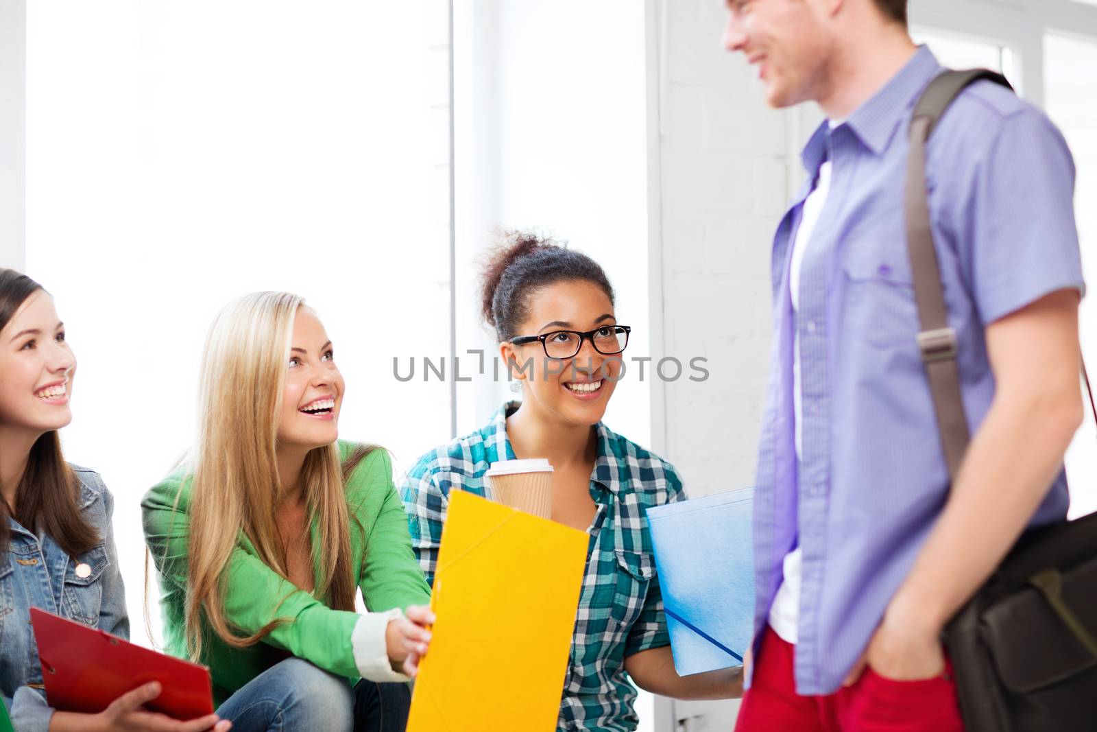 students communicating and laughing at school by dolgachov