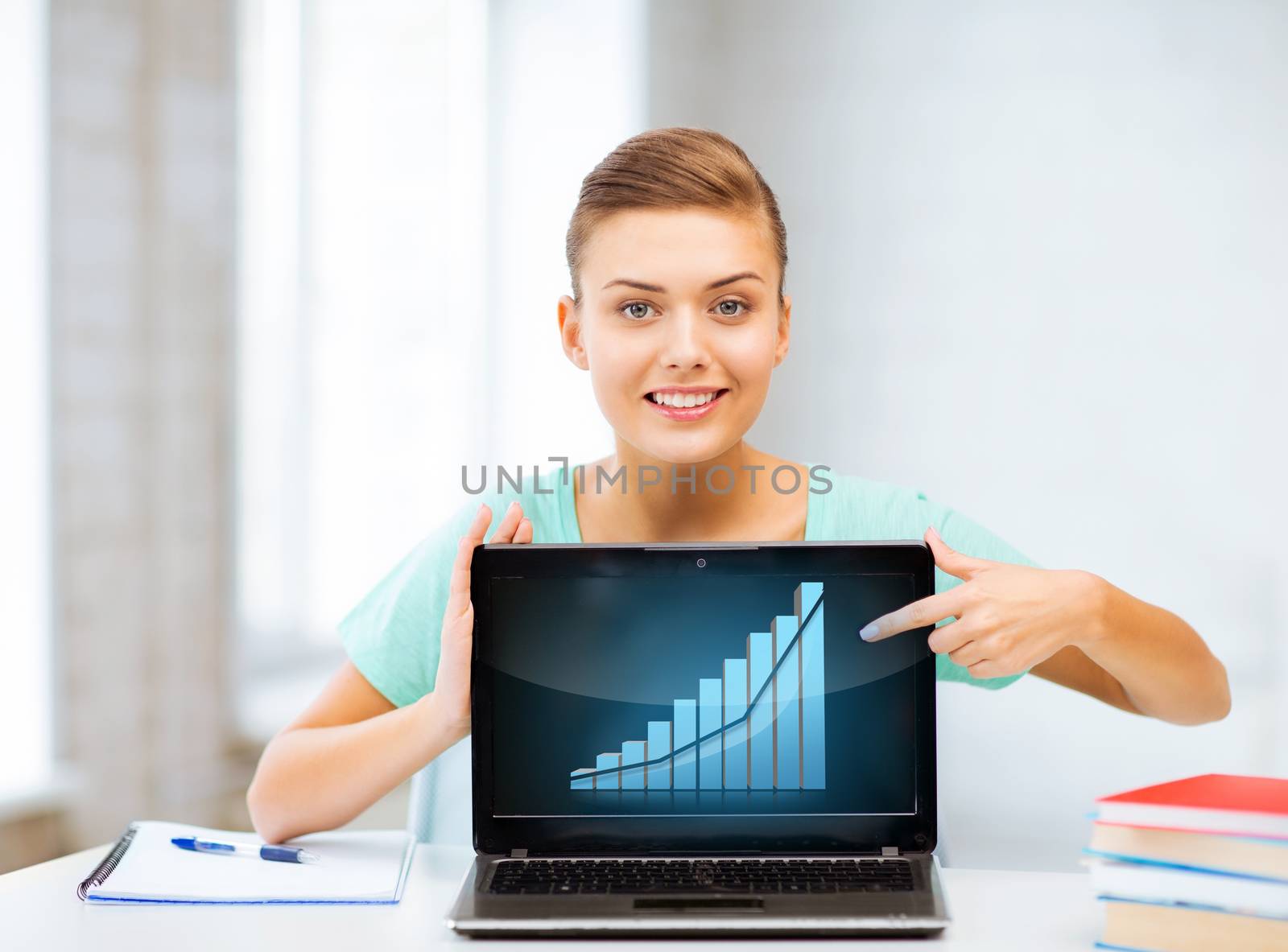 education and economics concept - student showing laptop with graph