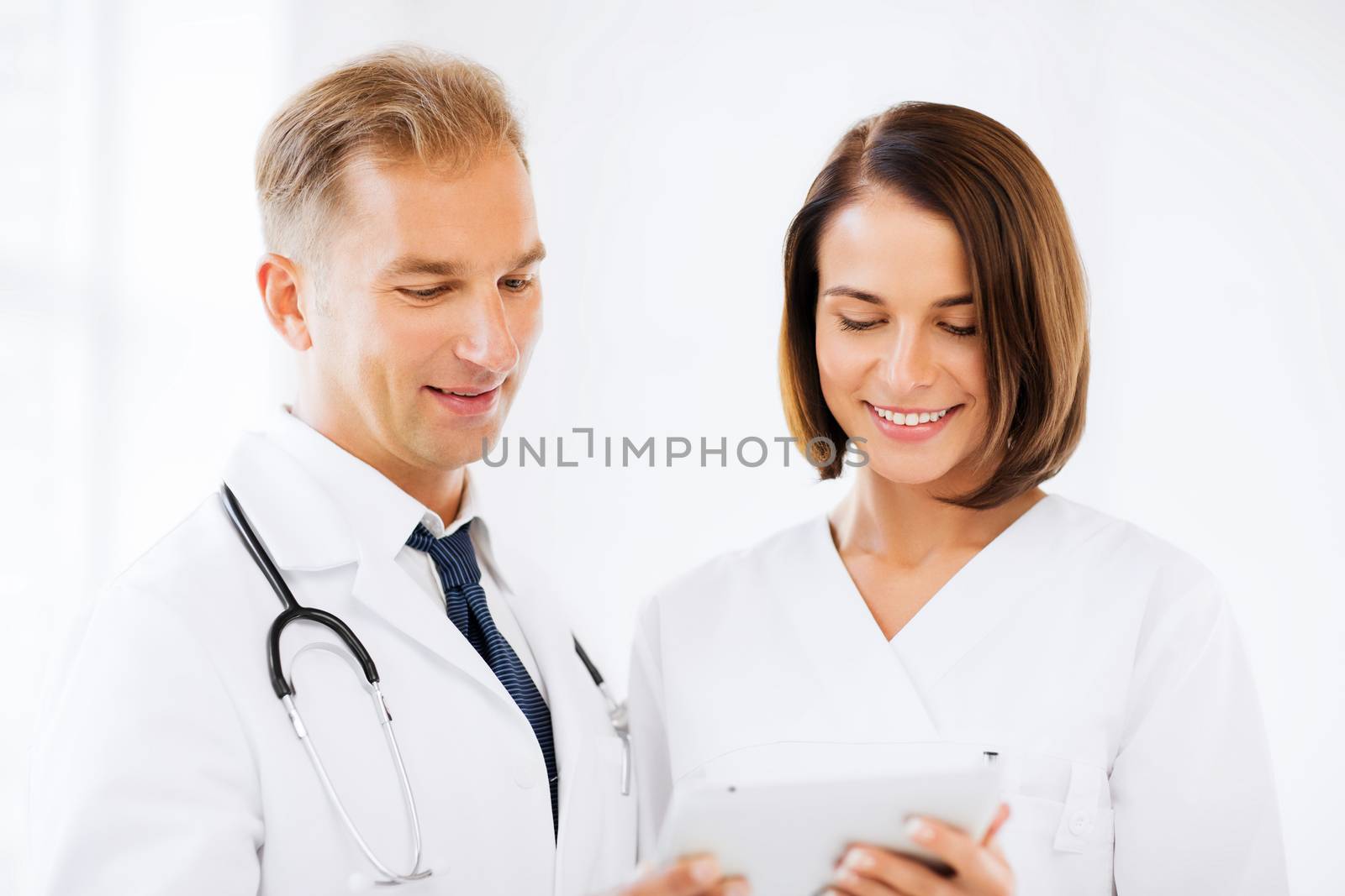 healthcare and technology concept - two doctors looking at tablet pc