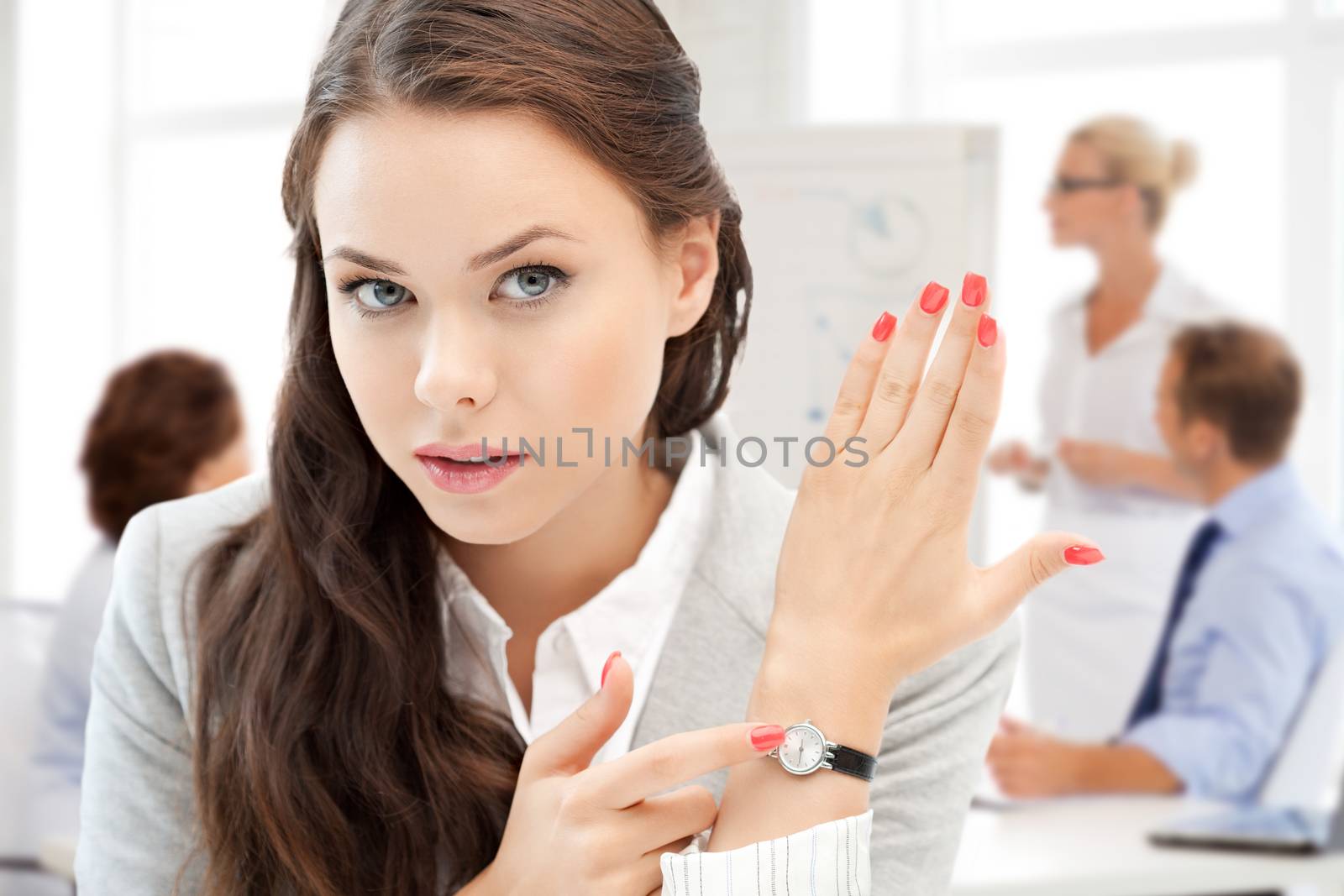 businesswoman pointing at her watch by dolgachov