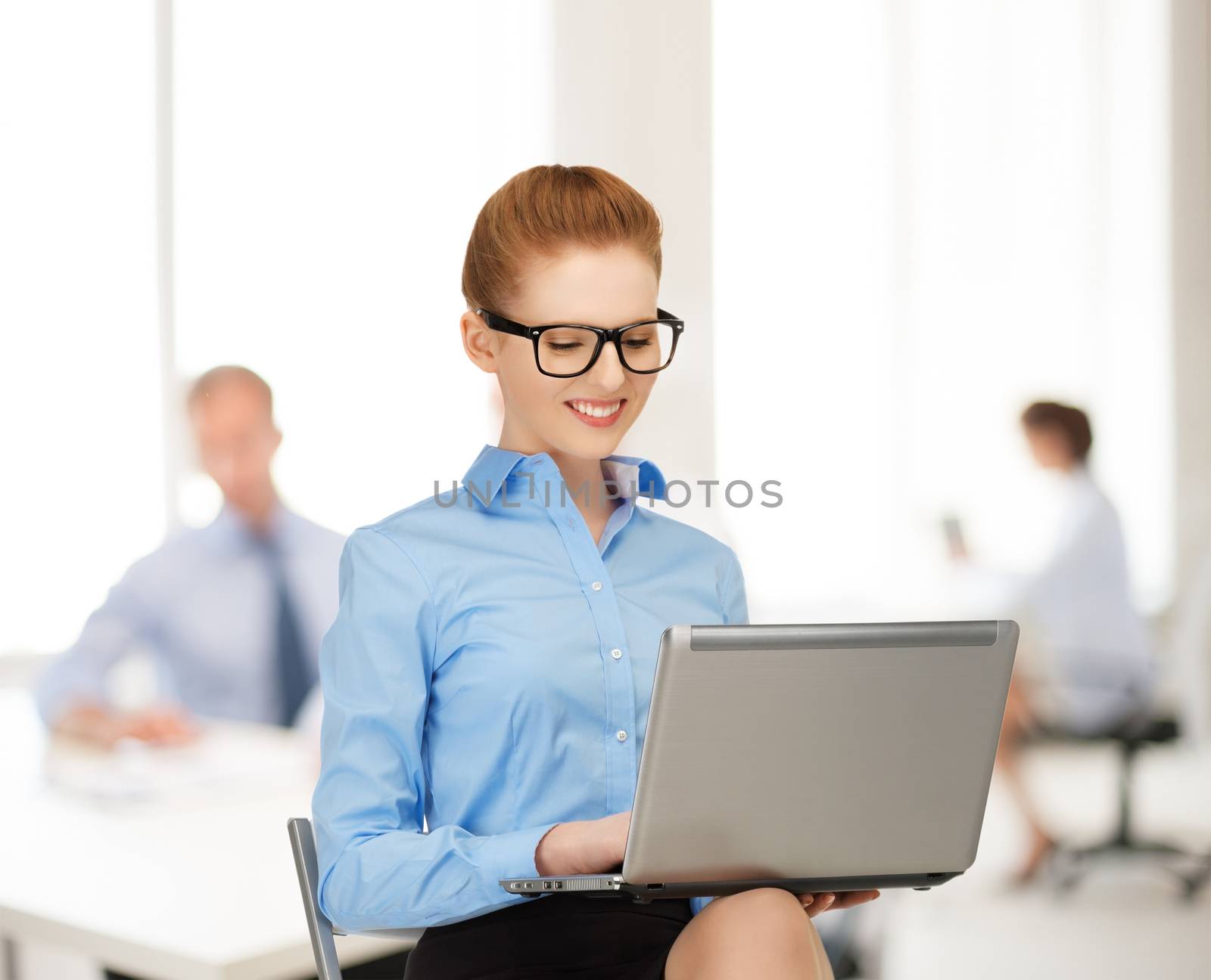 businesswoman with laptop computer at work by dolgachov