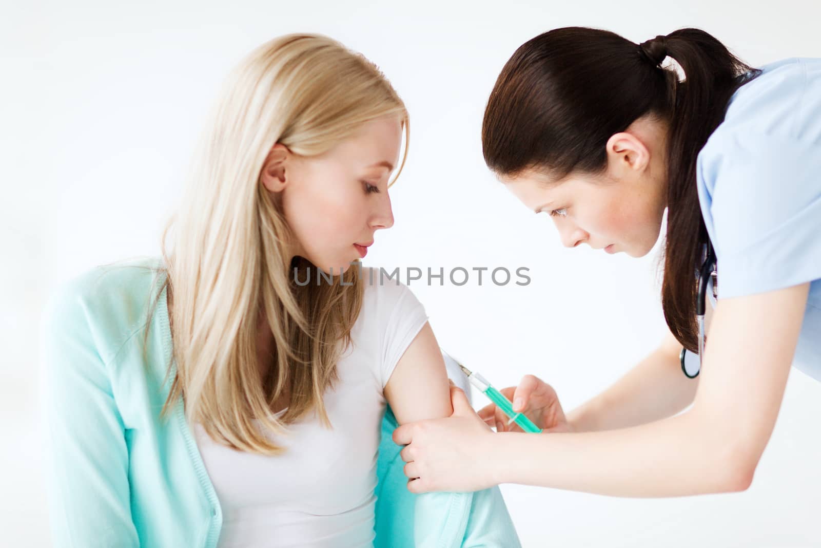 doctor doing vaccine to patient by dolgachov