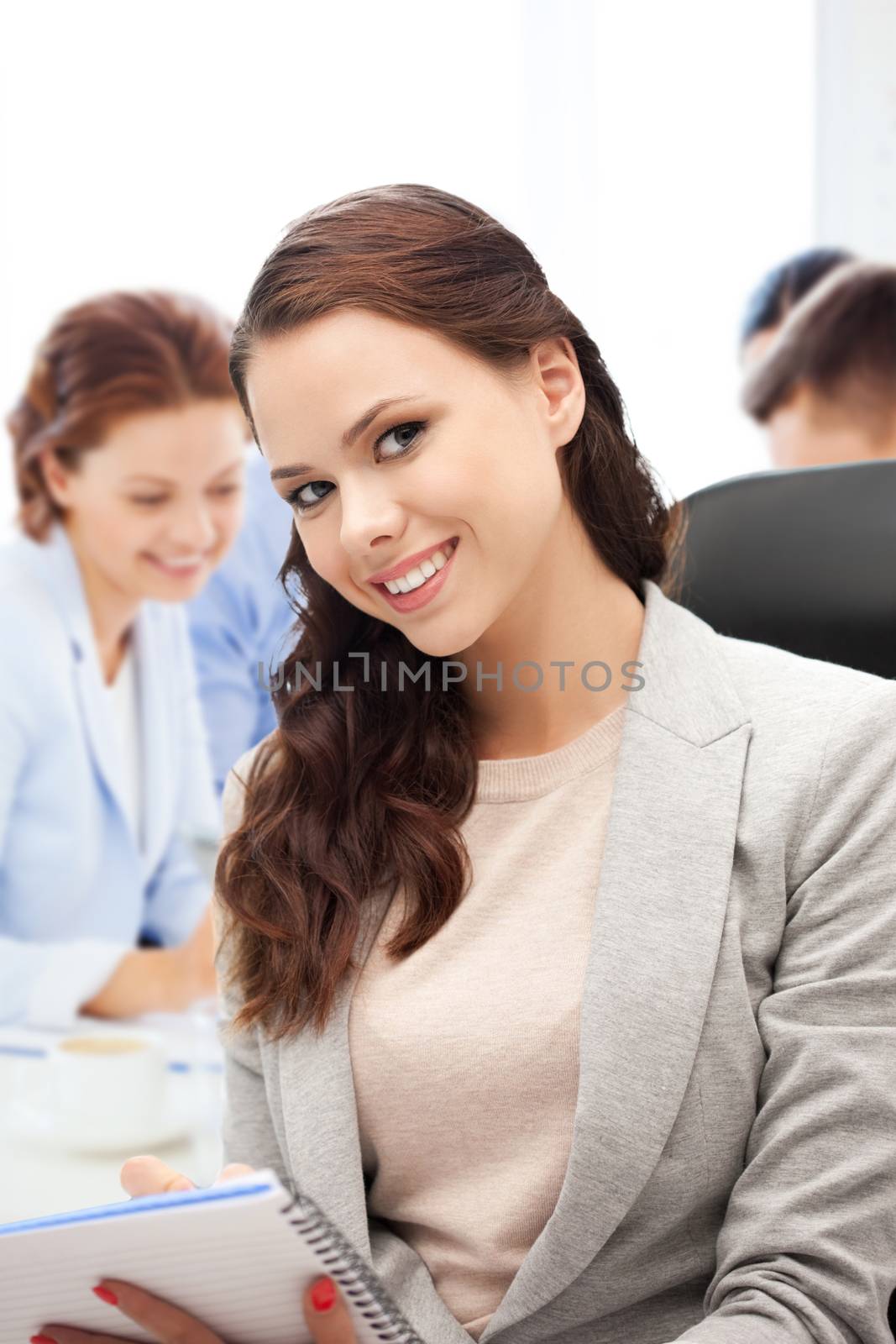 attractive businesswoman taking notes in office by dolgachov