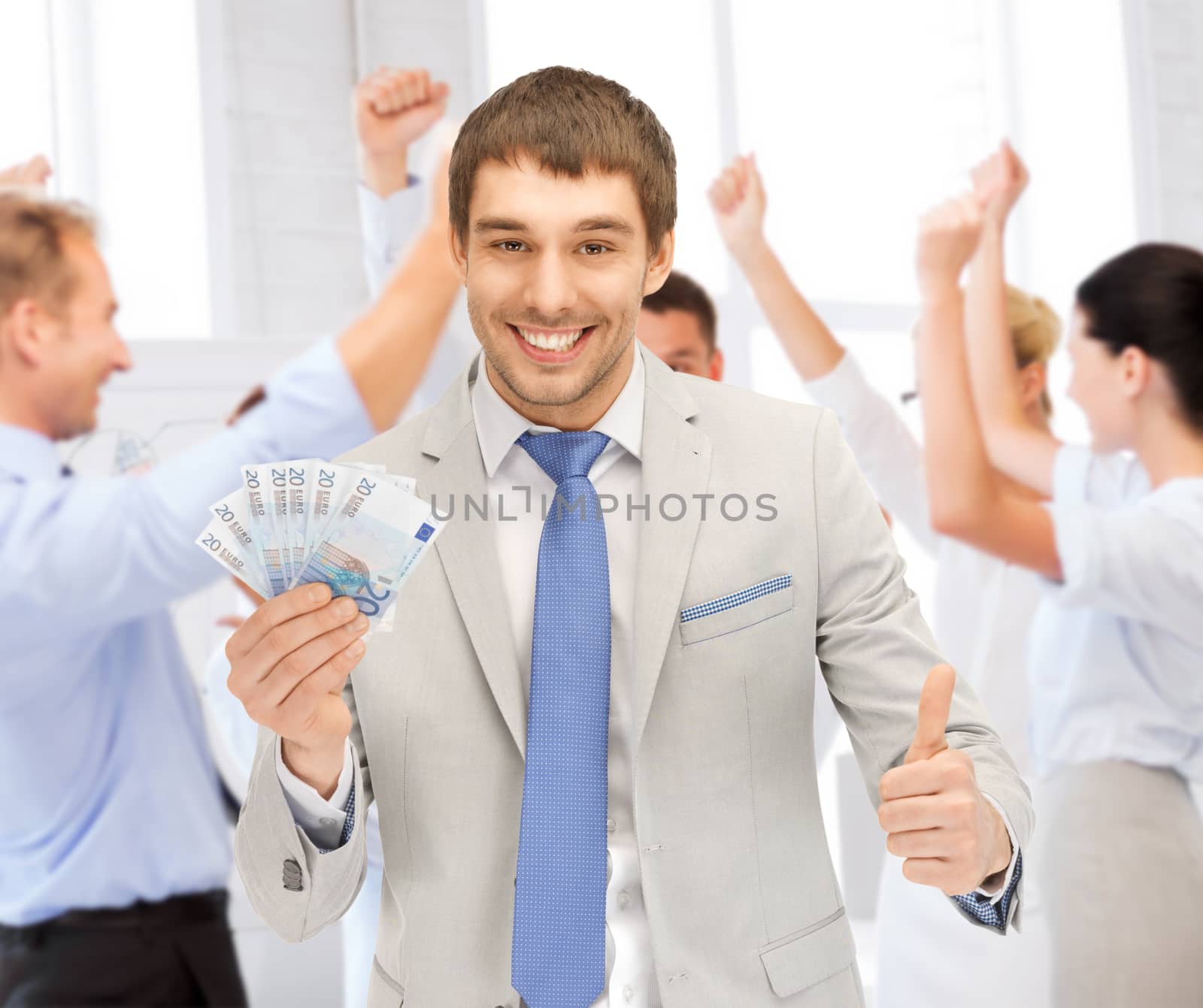 happy businessman with cash money in office by dolgachov