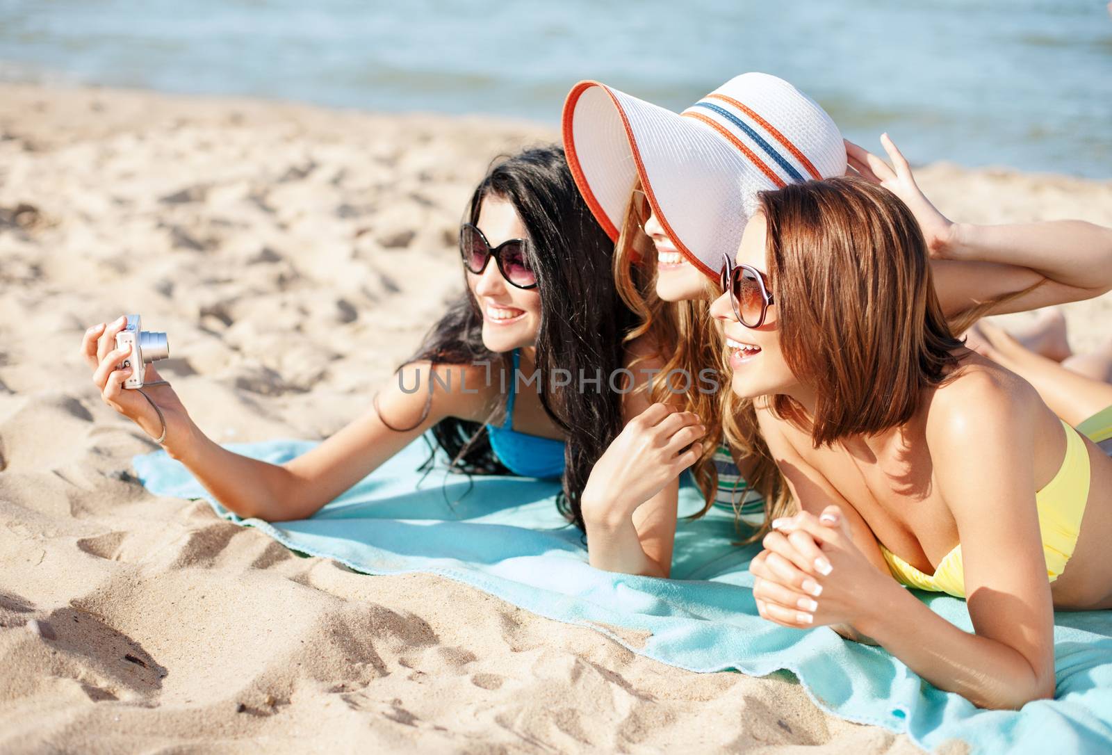 girls making self portrait on the beach by dolgachov
