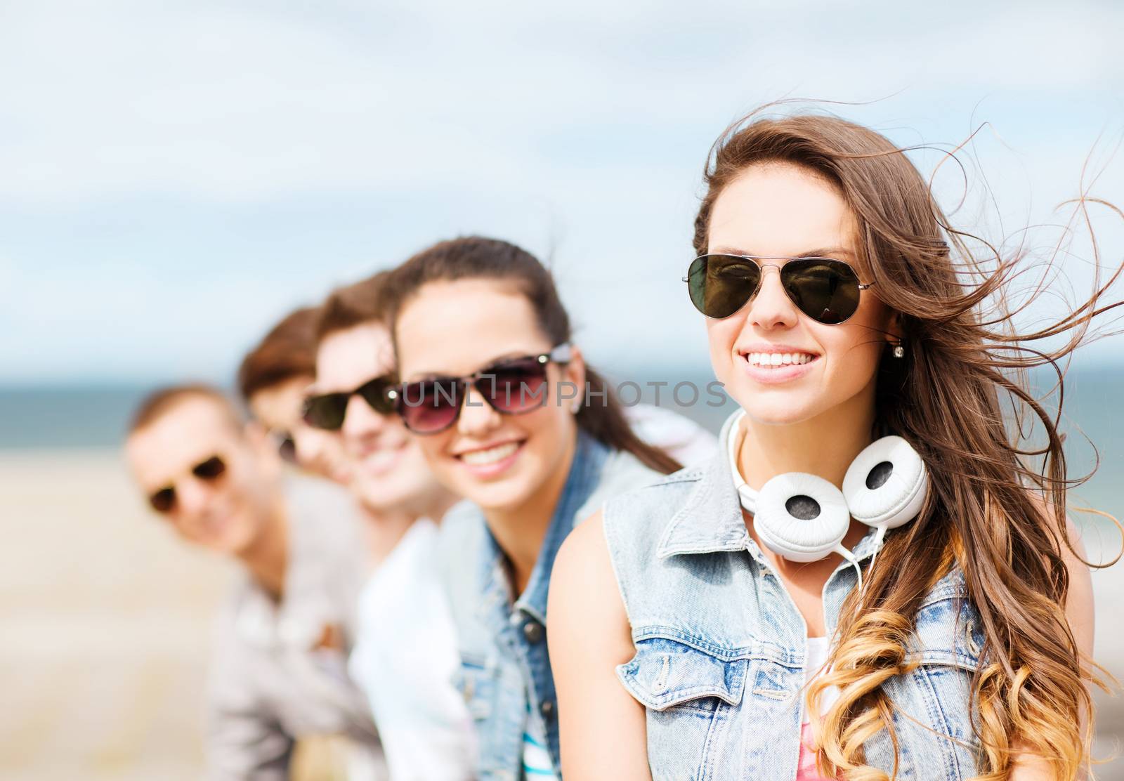 summer holidays and teenage concept - teenage girl with friends outside