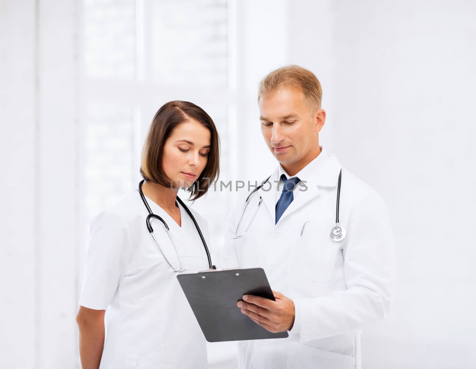 healthcare and medical concept - two doctors writing prescription